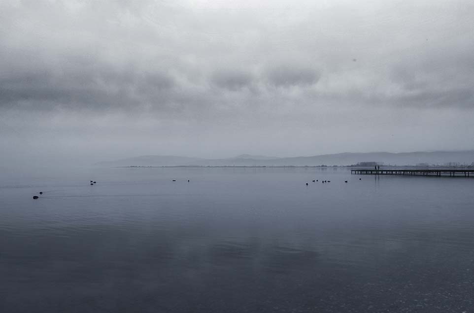 open foggy lake with mountains in the background